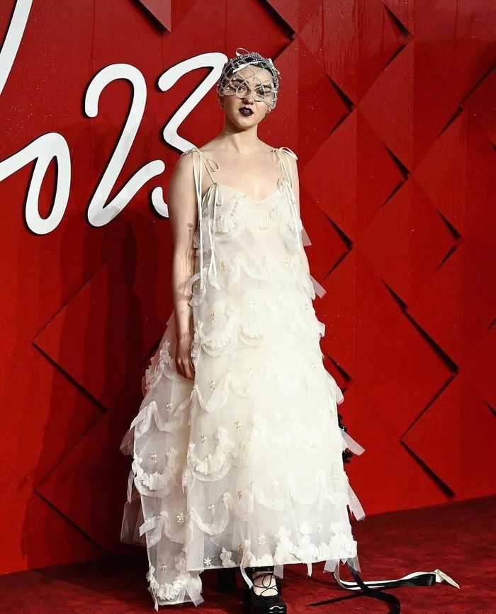 Dikenal eksentrik, Maisie Williams mengukuhkan gaya personal tersebut lewat gaun Simone Rocha. Tutu dress bertumpuk dengan bordiran tulle berkesan girly lebih unik dengan tatanan rambut serta head piece kristal menarik/ Foto: Instagram.com/simonerocha_