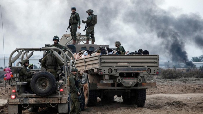 Palestinian detainees sit in a truck as Israeli soldiers guard around amid the ongoing conflict between Israel and the Palestinian Islamist group Hamas, in the Gaza Strip December 8, 2023.  REUTERS/Moti Milrod ISRAEL OUT. NO COMMERCIAL OR EDITORIAL SALES IN ISRAEL. EDITOR'S NOTE: REUTERS PHOTOGRAPHS WERE REVIEWED BY THE IDF AS PART OF THE CONDITIONS OF THE EMBED. NO PHOTOS WERE REMOVED.      TPX IMAGES OF THE DAY