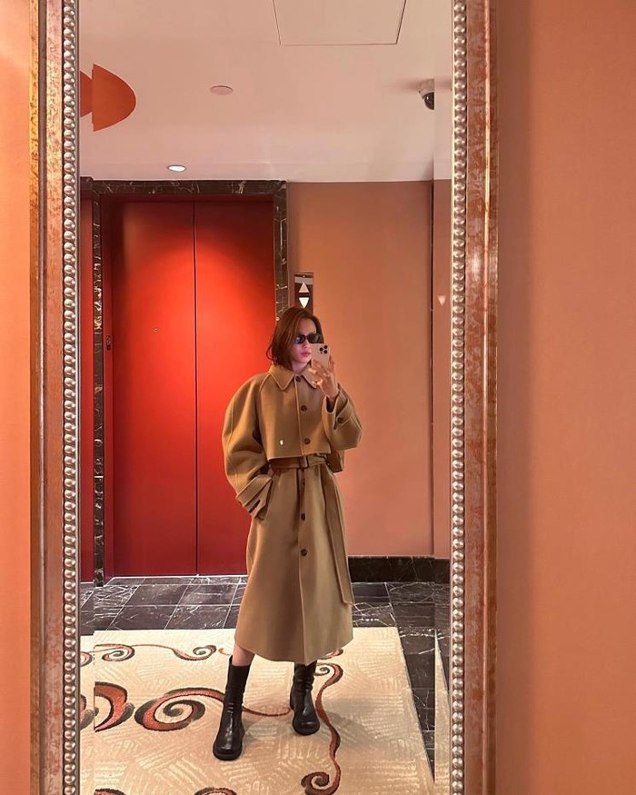 Meskipun basic, tampilan camel coat polos Go Min Si sangat menarik perhatian. Ia mengencangkan semua kancing dan melengkapinya dengan belt. Kacamata hitam dan sepatu boots menambah tampilannya menjadi lebih chic./ Foto: Elle.co.kr