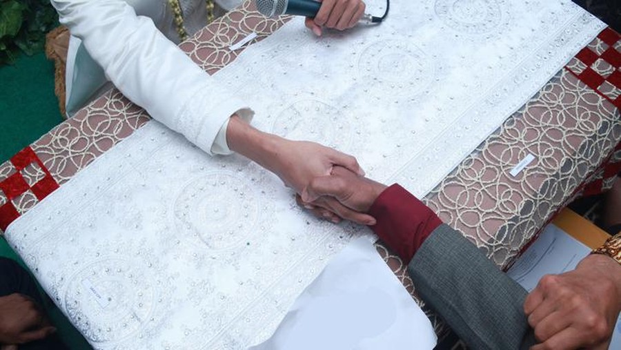 wali nikah islam Muslim wedding ceremony. The marriage process for Indonesian Muslim bride-to-be is called Ijab Kabul in Akad Nikah. handshake between the groom and the bride's father.