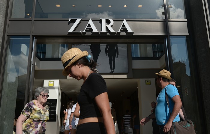 People walk past a Zara store in Barcelona, Spain, Wednesday, Aug. 27, 2014. Spanish fashion retailer Inditex says it has withdrawn a children's shirt which triggered an outcry from people who said it was reminiscent of the clothes Jews were made to wear at Nazi concentration camps. (AP Photo/Manu Fernandez)