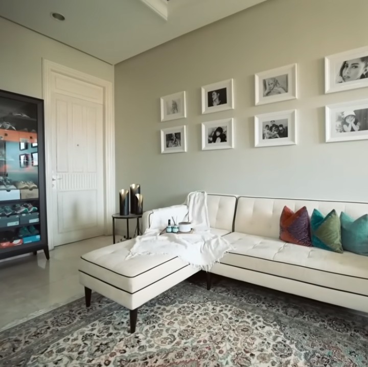 <p>Terakhir, yakni ruangan di lantai atas. Tepat di depan tangga, tersedia sofa lengkap dengan meja di sana. Di ruang ini juga terlihat sebuah lemari berisi barang-barang koleksinya. Menarik ya, Bunda? (Foto: YouTube AH)</p>
