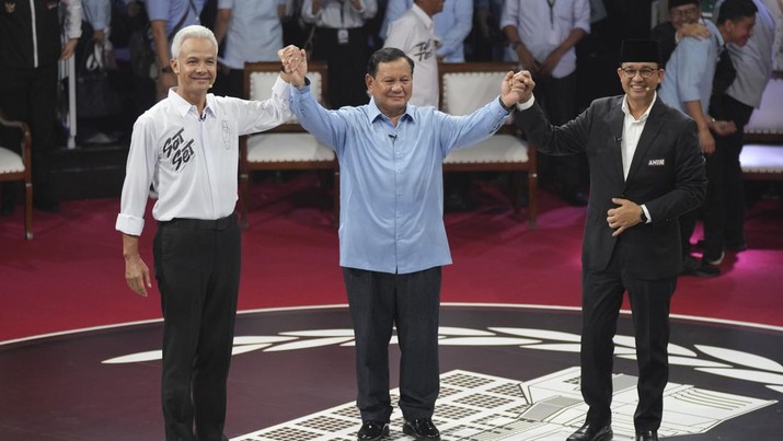 Presidential candidates, from left, Ganjar Pranowo, Prabowo Subianto and Anies Baswedan holds hands as they pose for photographers after the first presidential candidates' debate in Jakarta, Indonesia, Tuesday, Dec. 12, 2023. (AP Photo/Tatan Syuflana)
