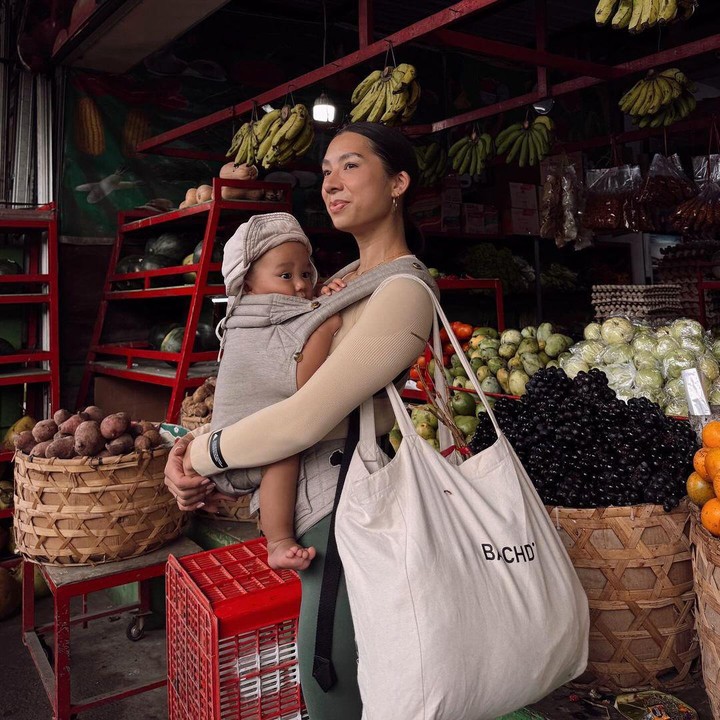 <p>Baby Kiro nampak sangat tenang digendongan Jennifer, meskipun tengah berbelanja di pasar tradisional. Foto ibu dan anak ini menjadi sorotan netizen karena berlatarkan dagangan khas pasar. (Foto: Instagram: @jenniferbachdim)</p>