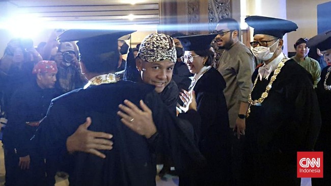 Calon presiden Ganjar Pranowo bertemu Mensesneg Pratikno di acara Dies Natalis Universitas Gadjah Mada (UGM). Mereka bersalaman dan berpelukan.