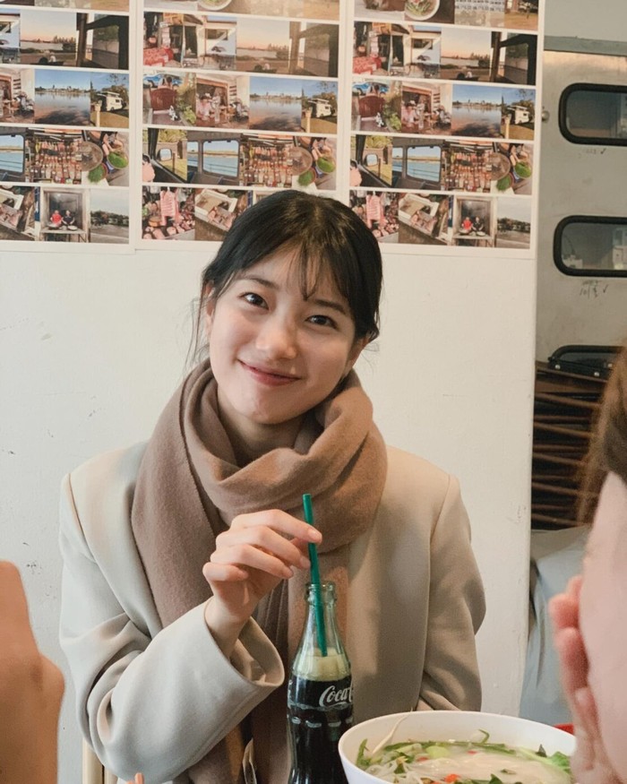 Suzy melengkapi tampilannya dengan syal coklat karamel untuk menambah kesan lembut. Karamel ​​merupakan warna yang cocok dipadukan dengan warna dasar outer seperti hitam, abu-abu, dan krem./ Foto: vougue.co.kr