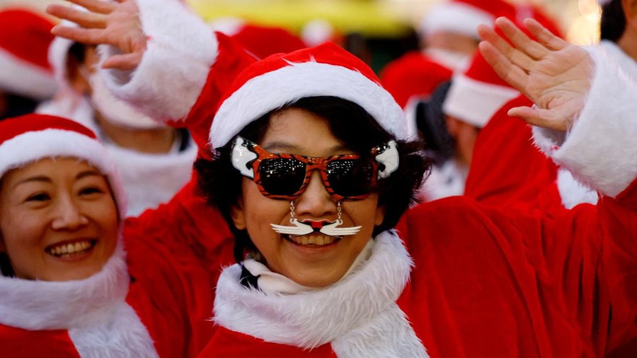 Participants wearing Santa Claus outfits wait for the start of an event to hand out gifts and clean up the street to celebrate the upcoming Christmas season in Tokyo, Japan December 22, 2023. REUTERS/Kim Kyung-Hoon