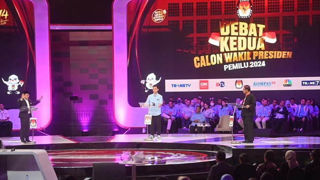 Calon Wakil Presiden nomor urut 2 Gibran Rakabuming Raka membungkukkan badan ke arah Muhaimin Iskandar dan Mahfud MD usai menjawab pertanyaan saat debat.
