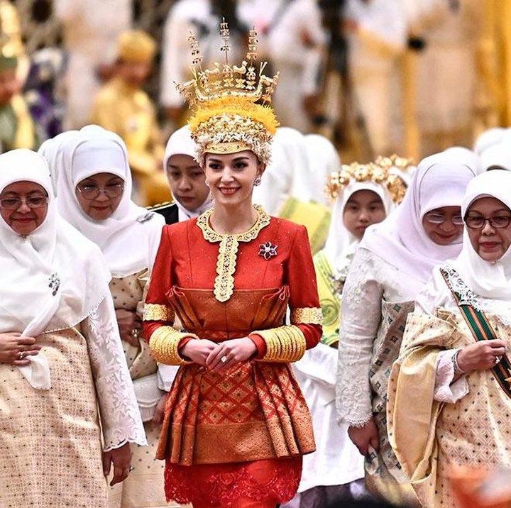 <p>Tak kalah memukau, Anisha Rosnah binti Adam atau yang dikenal sebagai Anisha Isa Kalebic tampil memesona dalam balutan busana bernuansa senada. Ia juga mengenakan ornamen <em>headpiece</em> emas di kepalanya. (Foto: Instagram @pelitabrunei)</p>