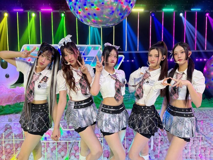 NewJeans menampilkan rambut yang menggemaskan dengan menambahkan pita kepala yang cute. Pita tersebut dikenakan dengan gaya yang berbeda, memberikan sentuhan ceria dan playful pada keseluruhan penampilan./ Foto: instagram.com/newjeans_official