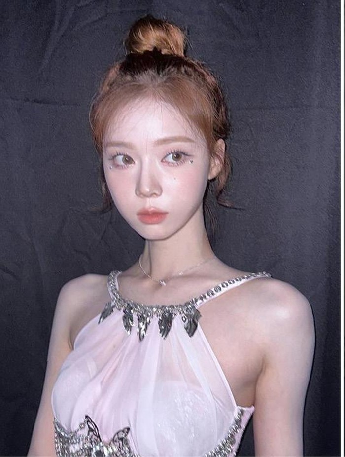 Winter menghiasi rambutnya dengan sanggul lucu dan pita hitam kecil sebagai aksesoris. Tampilannya terlihat semakin manis dipadukan dengan poni samping keriting alami. / Foto: allurekorea.com