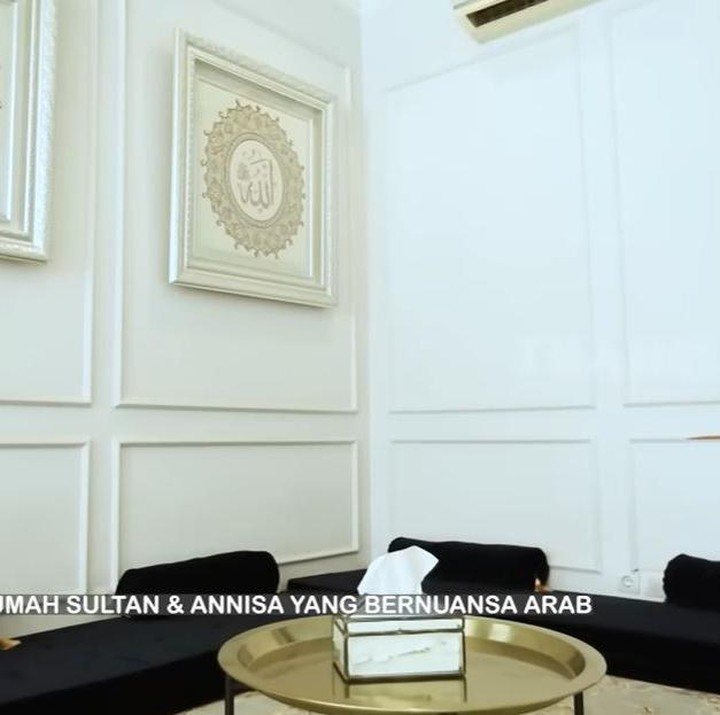 <p>Lanjut ke ruang tamu yang didesain dengan konsep lesehan tanpa sofa dan meja. Annisa dan Sultan mendesain ruang tamu yang disebur ruang Makkah ini dengan nuansa Arab. Desain dan pembangunan dinding di ruangan ini dikerjakan sendiri oleh Annisa dan Sultan lho. Pada pandemi lalu, Sultan mengaku mendempul dan memaku seluruh desain di ruangan tersebut. (Foto: YouTube TRANS7 OFFICIAL)</p>
