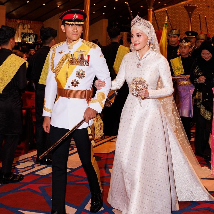 <p>Setelah menjalani akad nikah, Pangeran Mateen dan Anisha Isa akhirnya duduk bersanding di pelaminan dalam Majlis Istiadat Bersanding Pengantin Diraja yang dilaksanakan pada 14 Januari 2024. Pada kesempatan ini, Anisha terlihat anggun memakai gaun putih bersiluet<em> A-line. </em>Busana itu membuatnya jadi pusat perhatian ketika berjalan bersama Pangeran Mateen untuk menyapa masyarakat Brunei Darussalam. (Foto: Instagram: @tmski)</p>