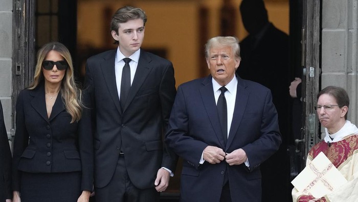 Former President Donald Trump, center right, stands with his wife Melania, second left, their son Barron, center left, and father-in-law Viktor Knavs, as the coffin carrying the remains of Amalija Knavs, the former first lady's mother, is carried into the Church of Bethesda-by-the-Sea for her funeral, in Palm Beach, Fla., Thursday, Jan. 18, 2024. (AP Photo/Rebecca Blackwell)