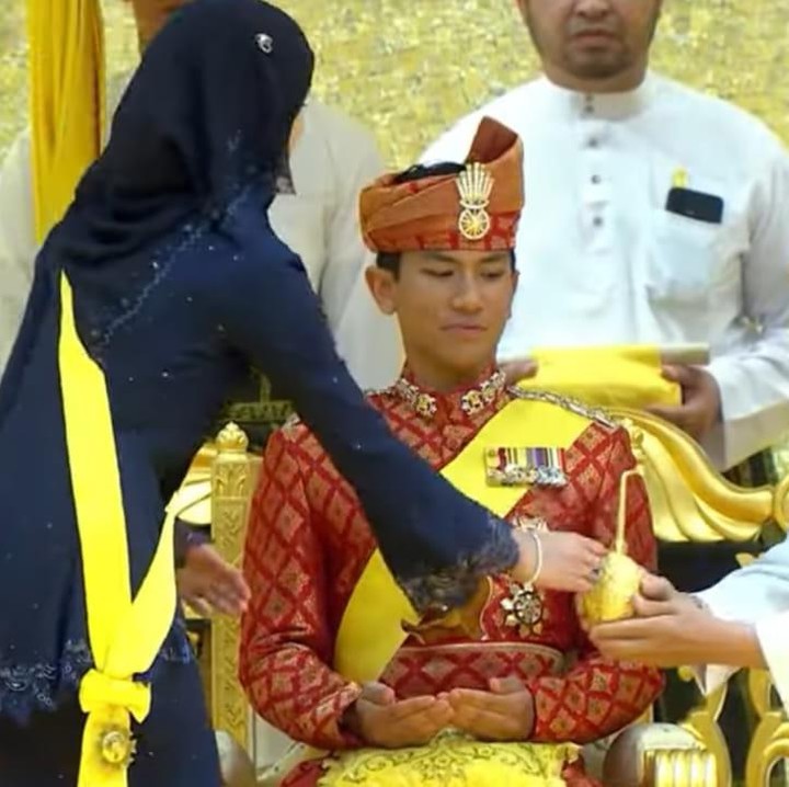 <p>Putri Ameerah yang berada di hadapan Pangeran Mateen juga melakukan adat tersebut dengan mengoleskan pasta bedak atau Bedak Diraja ke tangan sang kakak. (Foto: YouTube RTB)  </p>