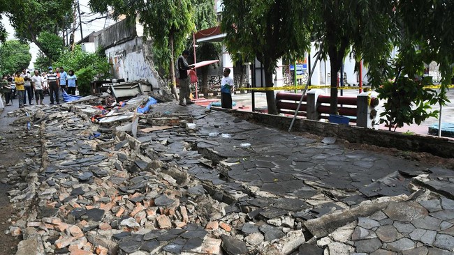 Sejumlah warga mengamati tembok yang roboh di Jalan Tebet Timur Dalam, Jakarta Selatan, Minggu (21/1/2024). Menurut warga, kejadian tembok roboh yang menimpa gerobak pedagang pada pukul 12.15 WIB itu mengakibatkan tiga orang meninggal dunia dan satu 