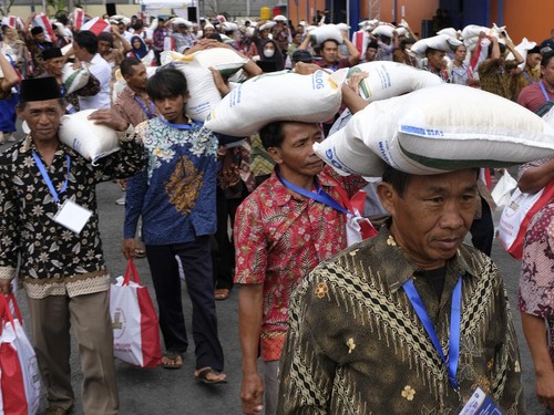 Sejumlah warga membawa beras dalam karung dan paket sembako saat penyerahan Bantuan Pangan Cadangan Beras Pemerintah (CBP) 2024 di Temanggung, Jawa Tengah, Senin (22/1/2024). Mulai awal tahun 2024 pemerintah melalui Badan Pangan Nasional, Perum Bulog