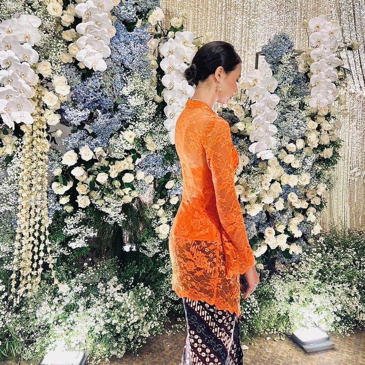 <p>Yuki Kato memadukan kebaya berbahan brukat warna oranye cerah. Ia memadukannya dengan kain batik berwarna cokelat yang dikenakan sebagai rok lilit. (Foto: Instagram @yukikt)</p>