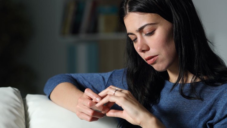 Confused woman looking at engagement ring