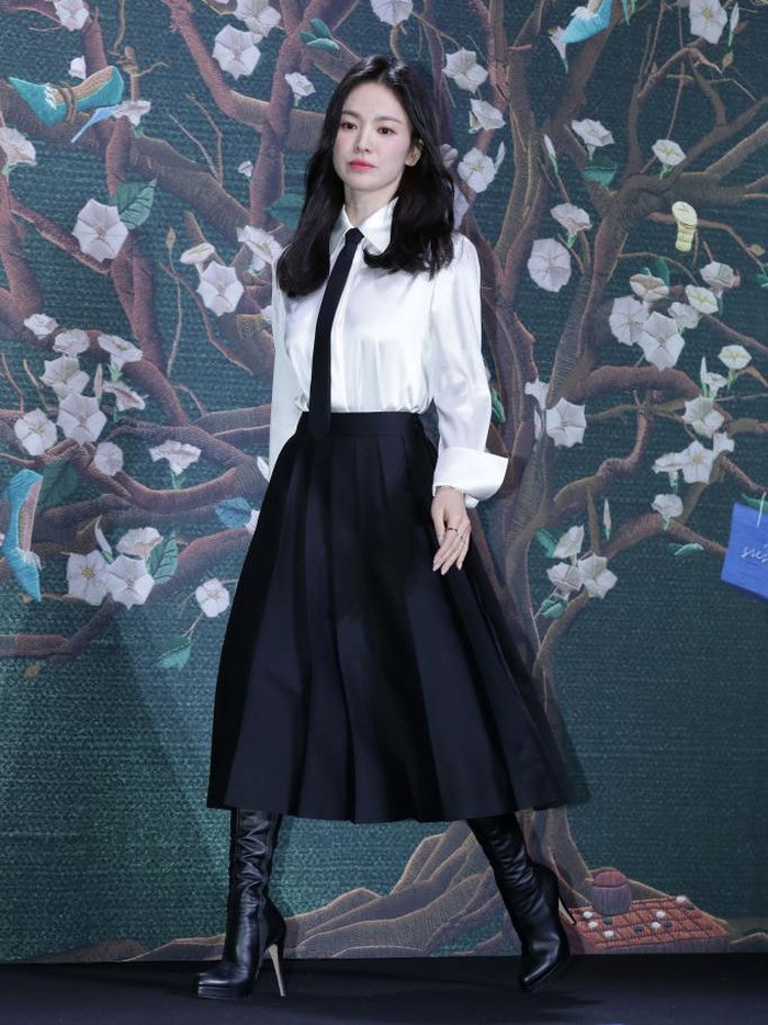 For a combination of feminine and boyish style, you can copy Song Hye Kyo's style, wearing a shirt, skirt, tie and a pair of long boots./ Photo: WireImage/Han Myung-Gu