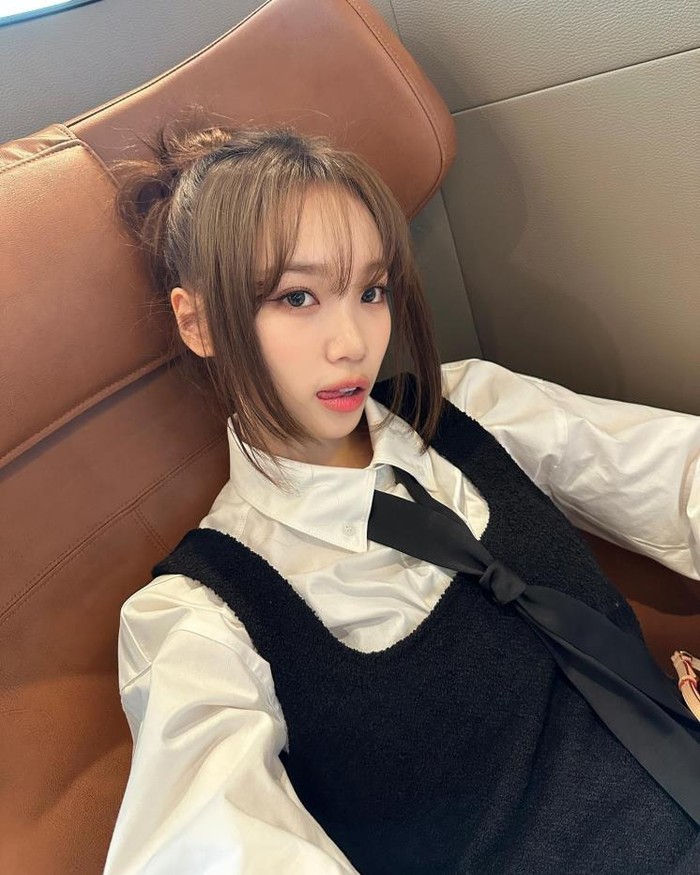 Chaewon dengan sempurna memadukan aksesoris dasi hitam ke dalam outfit kemeja putih dan dress hitam yang sederhana namun elegan. Paduan ini menciptakan kontras yang menarik antar elemen yang membuat tampilannya lebih bersinar./ Foto: Elle.co.kr