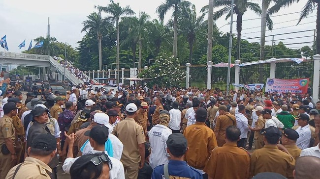 Pedemo dari Asosiasi Pemerintah Desa Seluruh Indonesia (APDESI) menggunakan palu besar untuk menghancurkan tembok Gedung DPR saat melakukan demonstrasi.