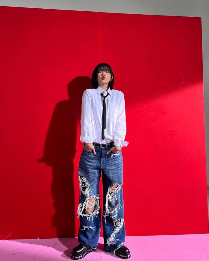 Yujin menggabungkan style modern dengan celana ripped jeans dan sepatu kemeja putih yang diakhiri dengan dasi hitam tipis. Tampilannya terlihat stylish dan unik yang membuatnya tampil edgy dan juga chic./ Foto: Elle.co.kr