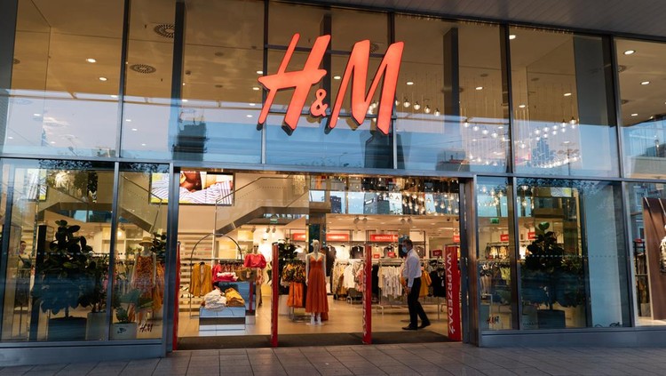 Warsaw, Poland - June 18, 2020: Entrance to H&M store, clothing retail company in the city center at night