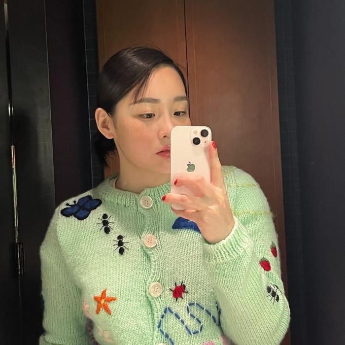 Kim Min Ha mencuri perhatian dengan kardigan lucunya yang dipenuhi dengan sulaman lucu, khususnya sulaman serangga berwarna-warni yang mencuat dengan jelas. Sentuhan artistik dari sulaman tersebut menambahkan nuansa playful dan quirky./ Foto: Elle.co.kr