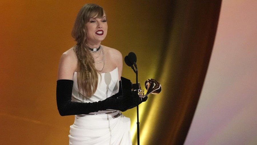 Mariah Carey, left, presents the award for best pop solo performance to Miley Cyrus for 