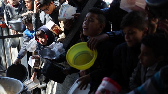 Sejumlah anak antre untuk menerima makanan pada dapur umum pengungsian di Rafah, Selatan Jalur Gaza, Senin (5/2/2024). (REUTERS/Ibraheem Abu Mustafa)
