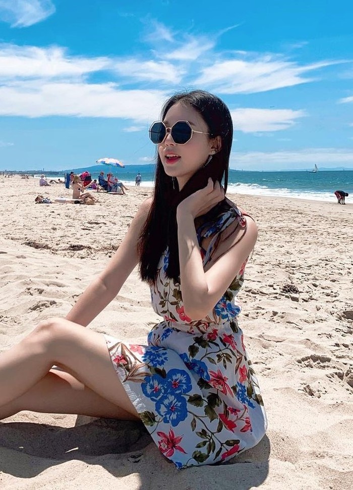 Yu Si Eun yang merupakan finalis Miss Korea 2022 ini tampil feminin dengan mini dress floral dan kacamata hitam saat menikmati hari cerah di pantai./ Foto: Instagram/yoo__si