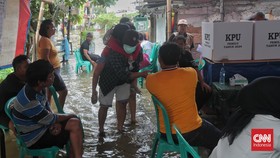FOTO: Warga Jakarta Tetap Ikut Pemilu 2024 Meski Kaki Terendam Banjir
