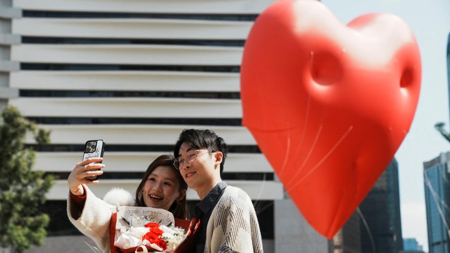 Visitors pose for pictures with a giant inflatable heart called 