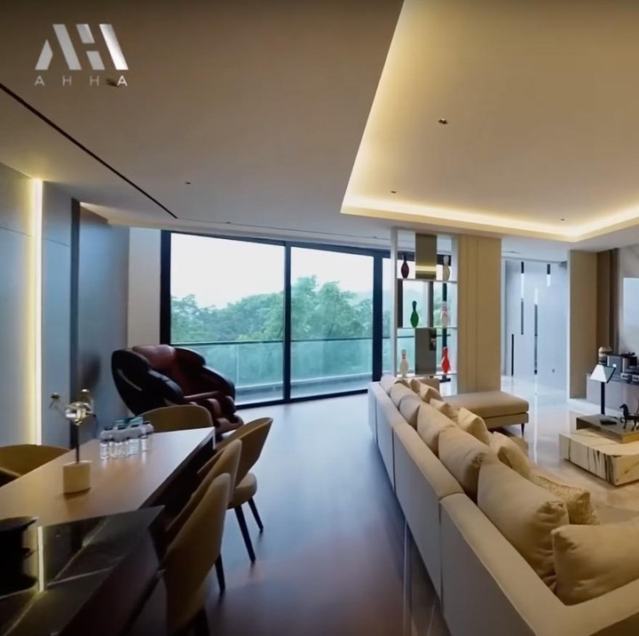 <p>Masuk lebih dalam, ada ruang keluarga yang sangat luas. Ruangan terbuka ini dilengkapi dengan sofa panjang, televisi, rak hiasan, dan terdapat kitchen island hingga meja makan di sisi belakang. (Foto: YouTube AH)<br /><br /><br /></p>