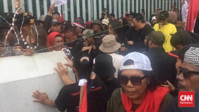 Massa yang melakukan aksi demonstrasi di depan Kantor Bawaslu RI, Jakarta Pusat, mencoba menerobos barikade yang dipasang polisi, Senin (19/2).