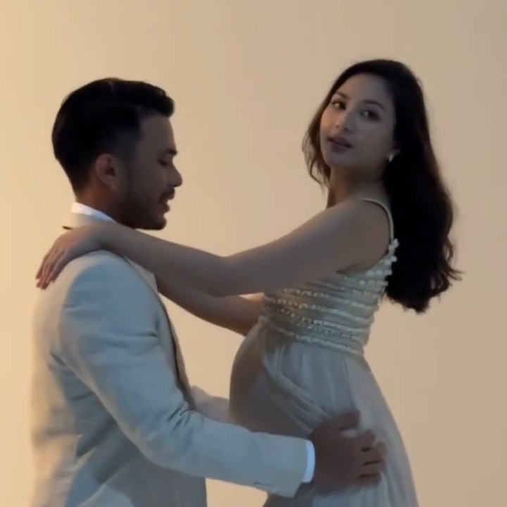 <p>Sesi foto kehamilan dilakukan secara simple di sebuah ruang studio bersama fotografer. Pasangan ini kompak mengenakan busana formal berwarna senada. (Foto: Instagram @jscmila)</p>
