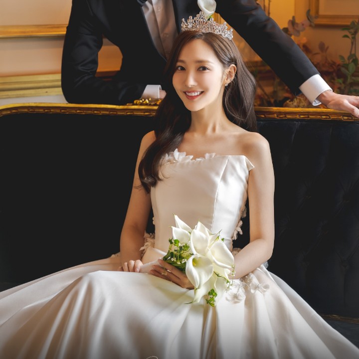 <p>Park Min Young dengan tiara di atas kepalanya terlihat kelewat cantik sambil duduk menggenggam bunga Lili yang melambangkan rasa cinta dan kasih sayang. (Foto: tvN)</p>