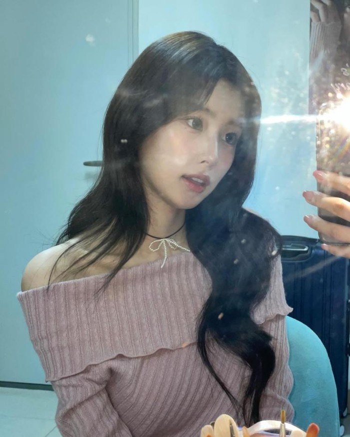 Kang Hye Won eks IZ*ONE sukses menunjukkan pesona cantiknya yang polos dalam balutan off-shoulder. Unsur girly tidak terlewatkan dengan menambahkan choker berhiaskan pita mutiara sebagai highlight./ Foto: elle.co.kr