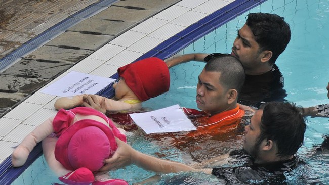 Yudha Arfandi, tersangka pembunuhan Dante (6) anak dari Tamara Tyasmara, memperagakan adegan rekonstruksi menenggelamkan korban di kolam renang.