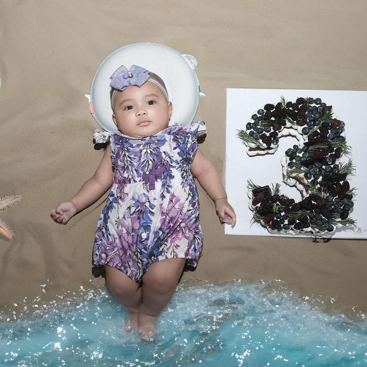 <p>Untuk memeringati usianya ini, Azura pun menjalani sesi newborn photoshoot, Bunda. Ia terlihat semakin menggemaskan dengan pakaian santai warna ungu dan bando senada. (Foto: Instagram: @aurelie.hermansyah/@attahalilintar)</p>