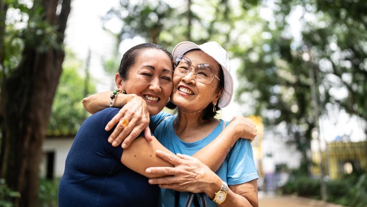 Mother and daughter embracing on the public park
