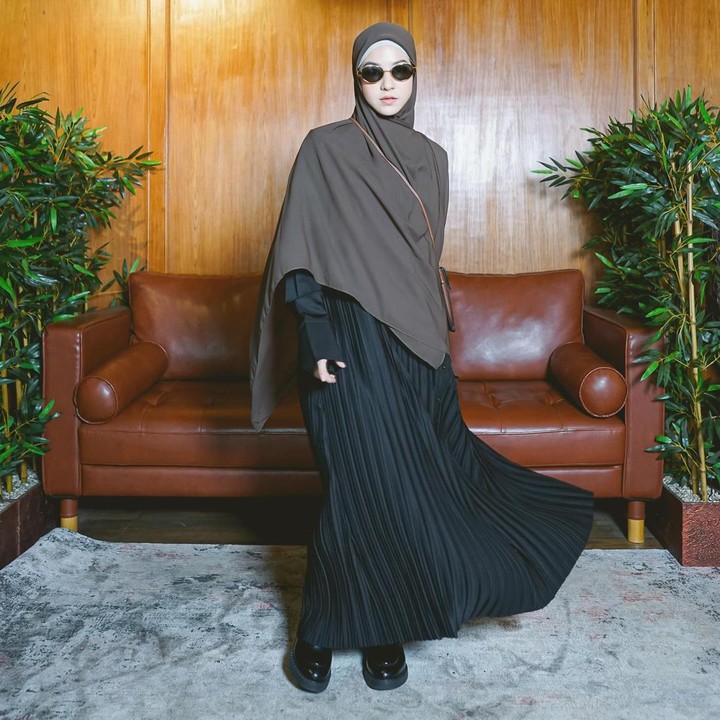 <p>Untuk tampilan kasual, Bunda juga boleh mencoba padu padan rok plisket dan atasan berwarna gelap. Penggunaan warna-warna seperti hitam dan cokelat akan memberi kesan santai pada <em>outfit</em> yang dikenakan. Bunda bisa memberikan sentuhan manis dengan <em>sunglasses.</em> (Foto: Instagram @natasharizkynew)</p>