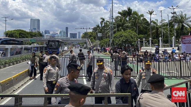 Polisi mengalihkan arus lalu lintas di Jalan Gatot Subroto depan Gedung DPR/MPR imbas aksi demonstrasi