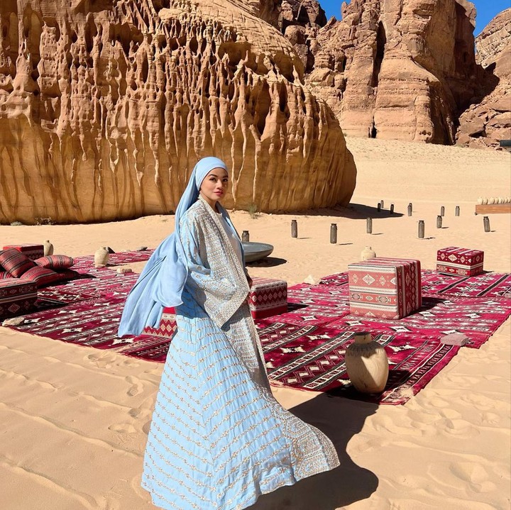 <p>Selanjutnya, ada padu padan gamis bercorak etnik dengan hijab turban. Kali ini, Titi Kamal memilih nuansa pastel yang lembut. Ia mengenakan baju dan hijab warna<em> baby blue</em> yang berpadu manis dengan warna <em>beige</em> pada corak bajunya. (Foto: Instagram @titi_kamall)</p>