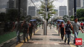 Para pekerja di Jakarta beraktifitas di pagi hari, sebagian mereka menuju gedung kantor yang berada di kawasan Bundaran HI, Sudirman, Jakarta Pusat, Rabu (6/3/2024). (CNN Indonesia/Ramadhan Nur Fadillah)