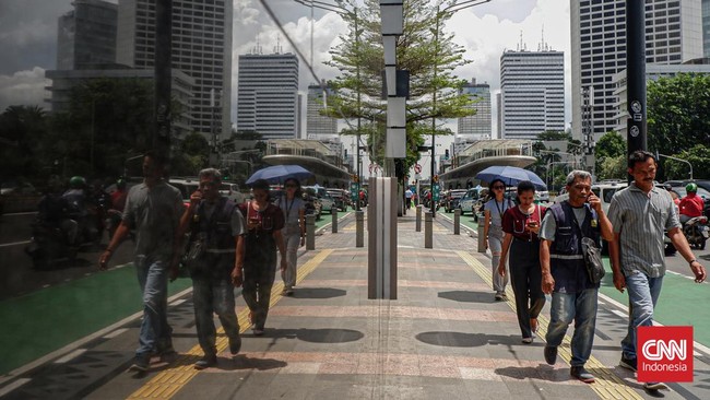 Para pekerja di Jakarta beraktifitas di pagi hari, sebagian mereka menuju gedung kantor yang berada di kawasan Bundaran HI, Sudirman, Jakarta Pusat, Rabu (6/3/2024). (CNN Indonesia/Ramadhan Nur Fadillah)