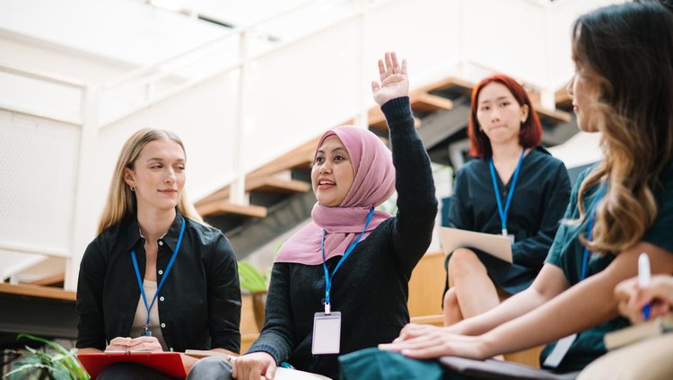 Asian Malay female is raising hand during a seminar in board room.