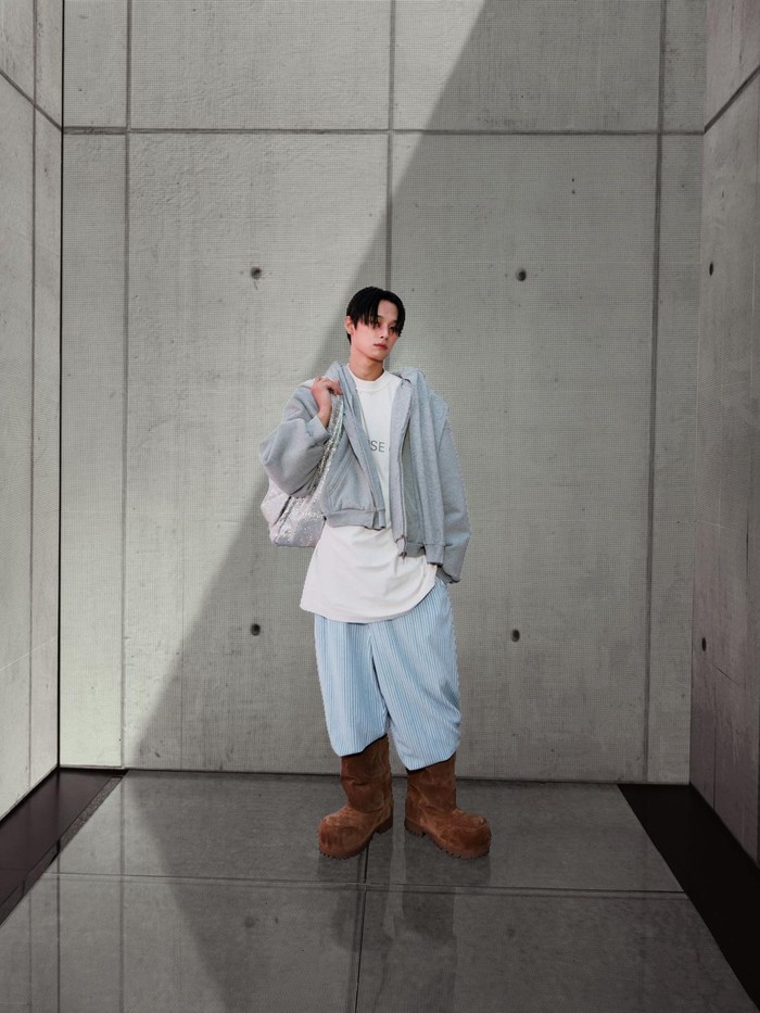 Juyeon member grup The Boyz tak kalah menarik perhatian dengan perpaduan kaus dan celana panjang bergaris serta jaket abu. Chunky boots material suede yang dikenakannya jadi pusat perhatian gaya ini/ Foto: Courtesy of Balenciaga