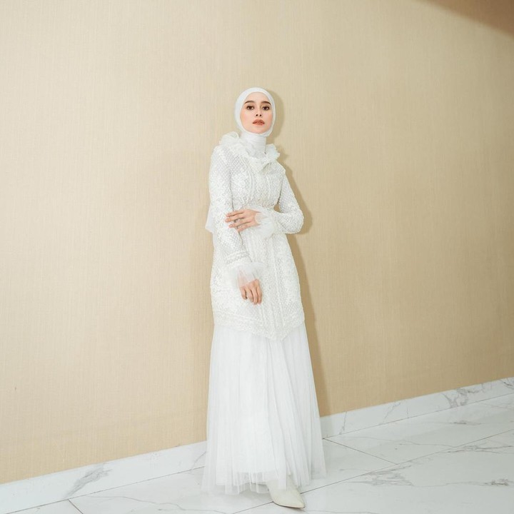 <p>Tampilan formal Lesti dengan gamis serba putih juga membuatnya tak kalah elegan. Ia memadukan gamis tersebut dengan hijab dan sepatu berwarna senada. (Foto: Instagram @lestikejora)</p>